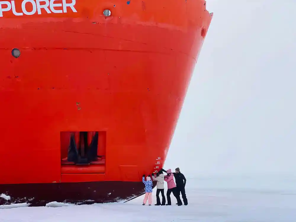 The bow close up in red with a small group posed at its foot