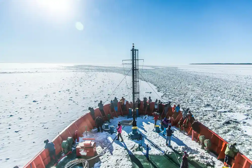 The foredeck looking forward over the ice with passengers along the rail