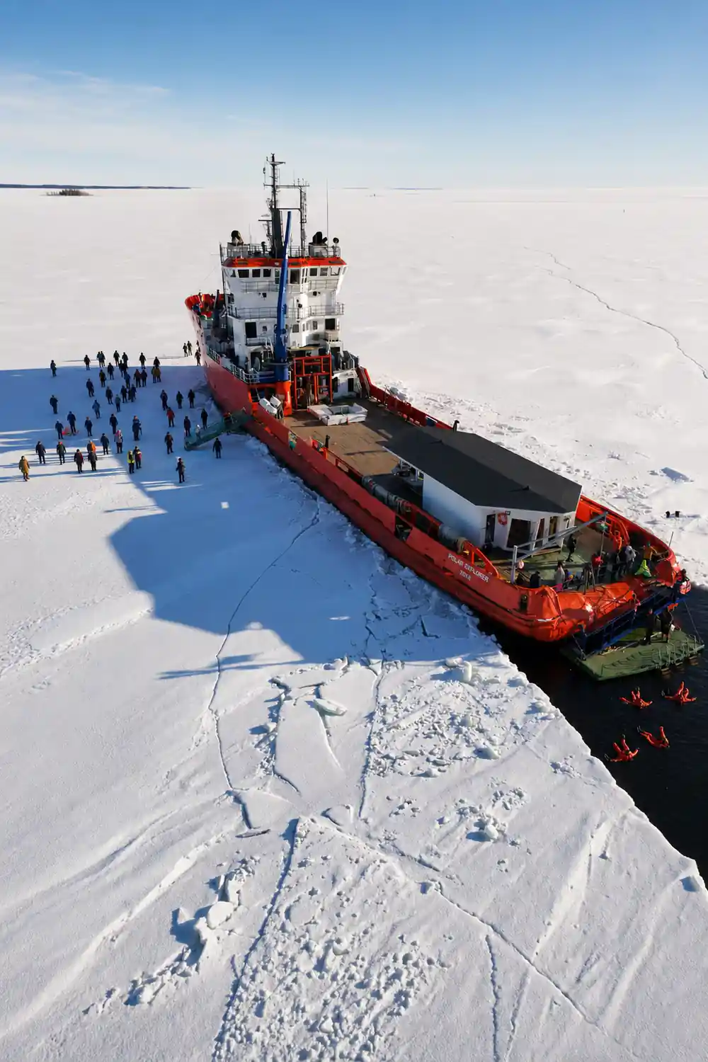 The icebreaker alongside the ice edge with a line of passengers on the floe