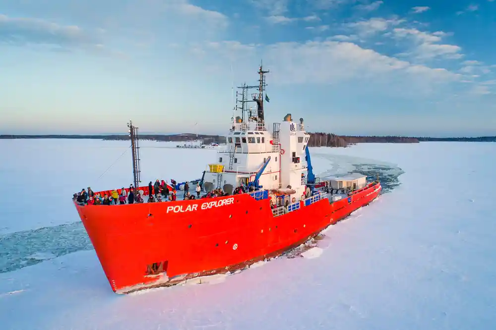 The icebreaker under way with passengers lining the open deck