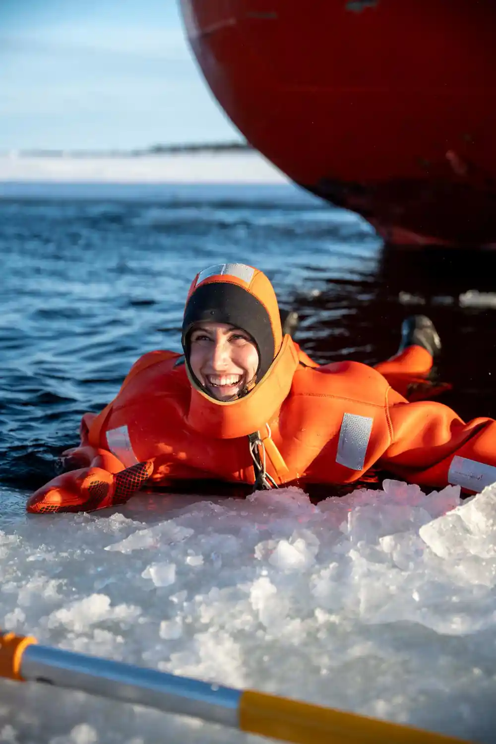 A passenger in a survival suit resting on broken ice at the channel edge