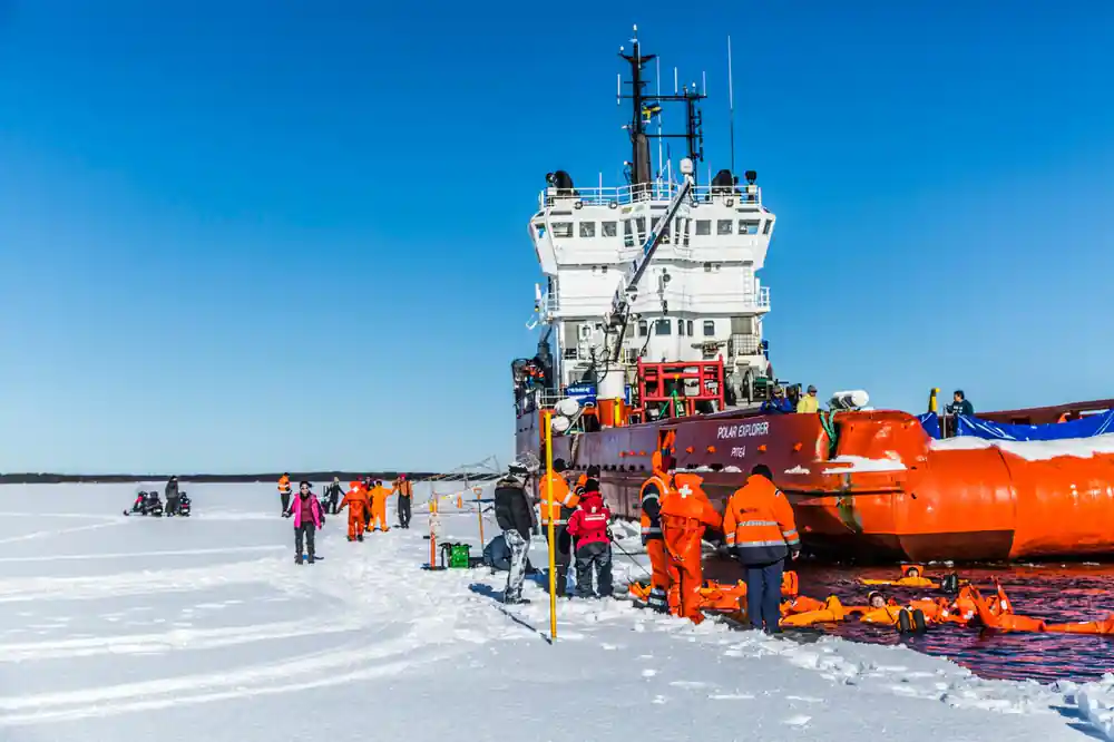 The ship alongside the ice with the boarding area and passengers below