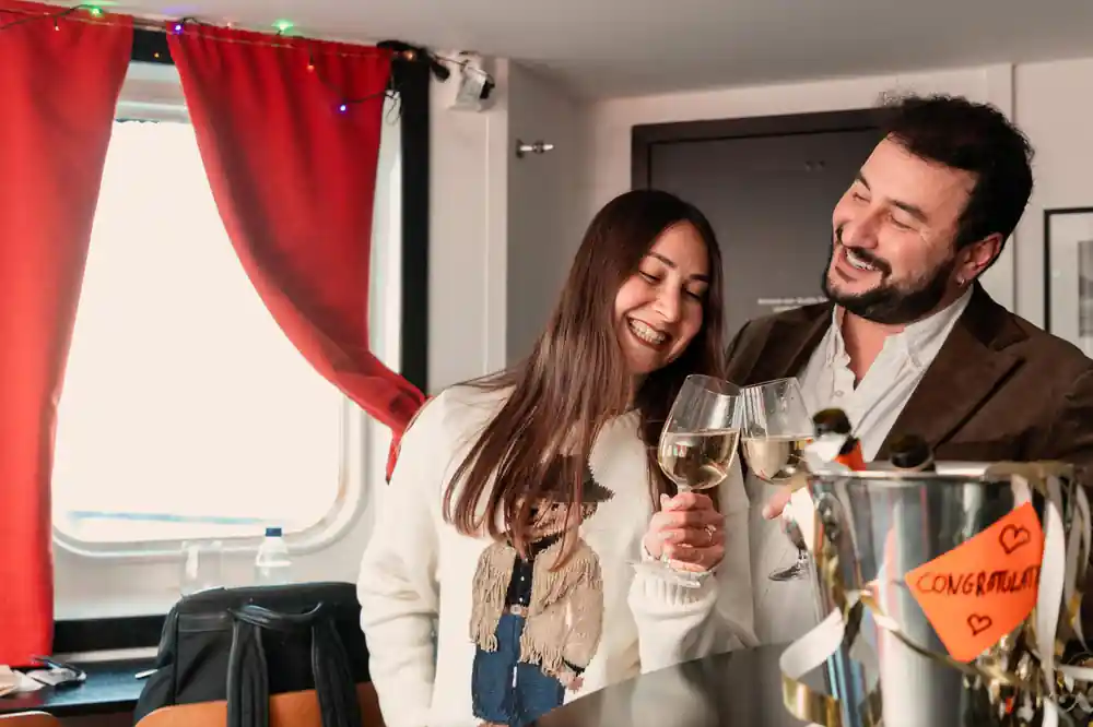 Two passengers with drinks in a warm cabin on board