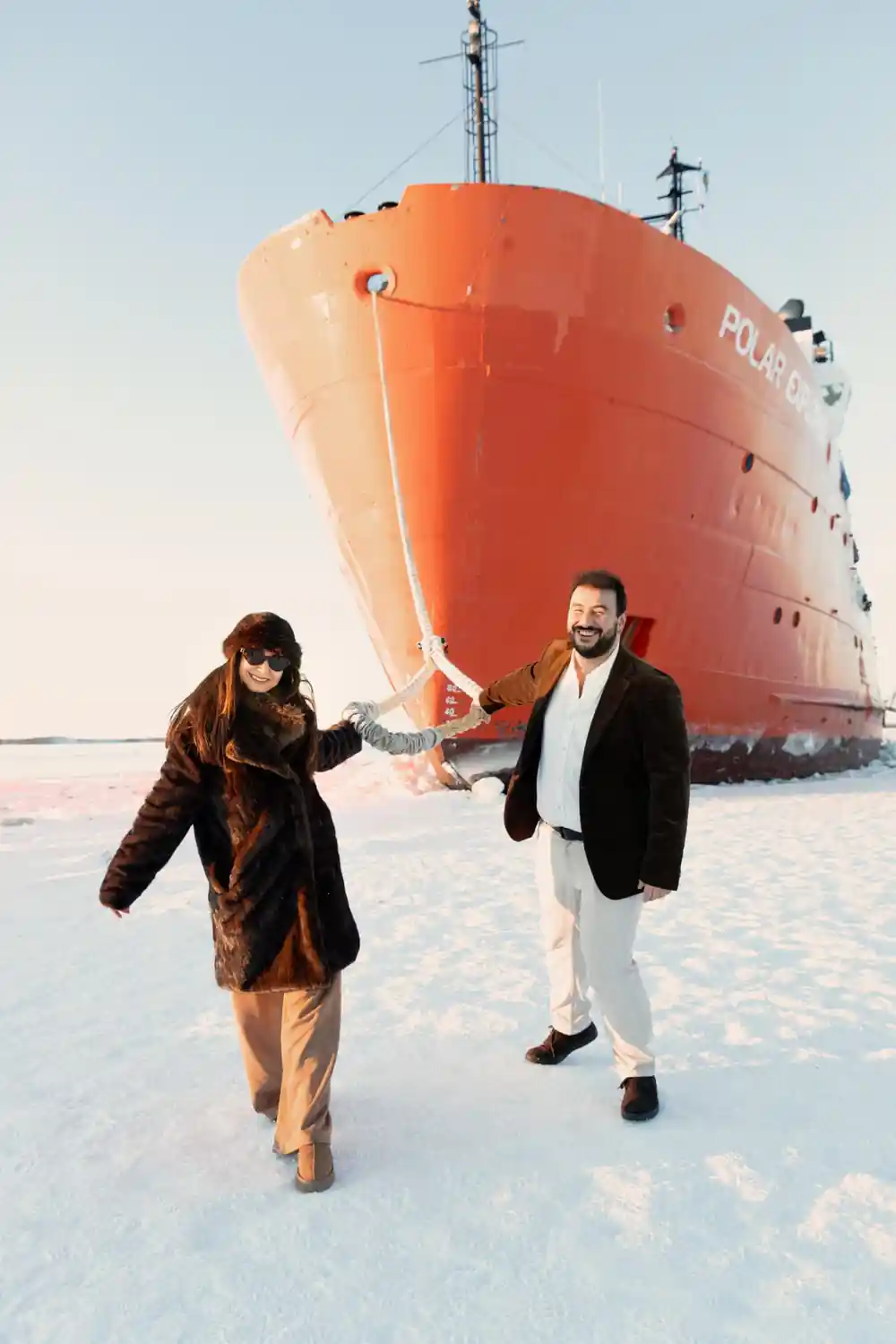 Two passengers posed at the bow of the icebreaker on the ice